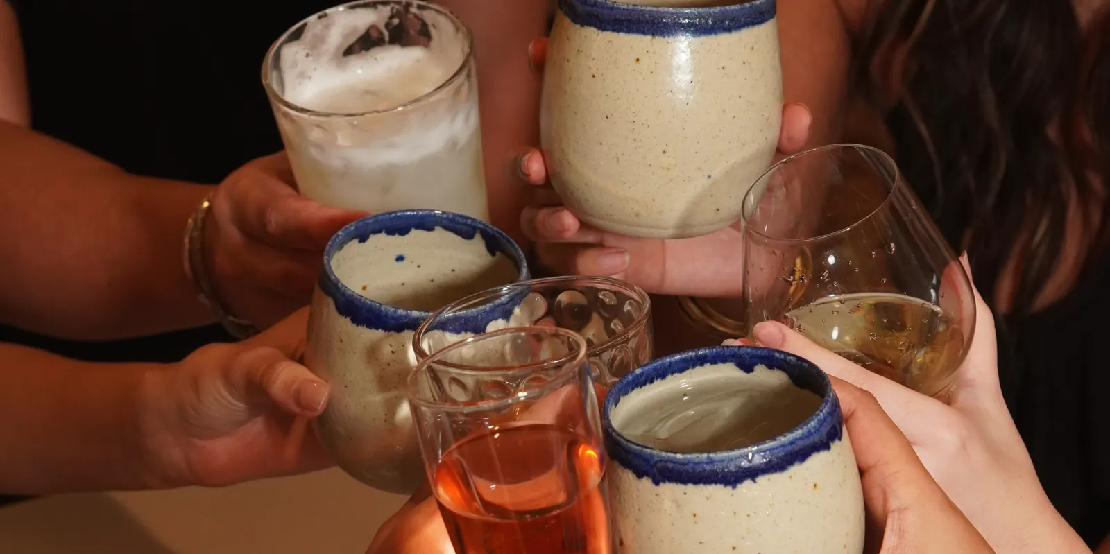 A toast across the table with Aqui’s blue-rimmed cups and a glass of rosé